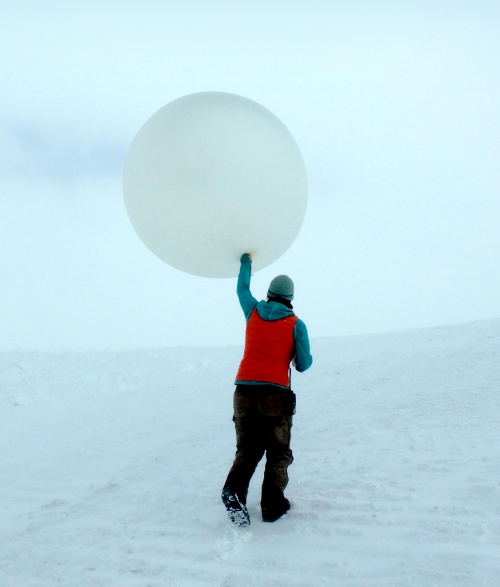 Science technician Marci Beitch prepares to launch a weather balloon from Summit Station, Greenland.